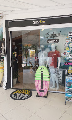 Fachada da SURFLIFE em Juquehy, com a entrada da loja e uma prancha colorida