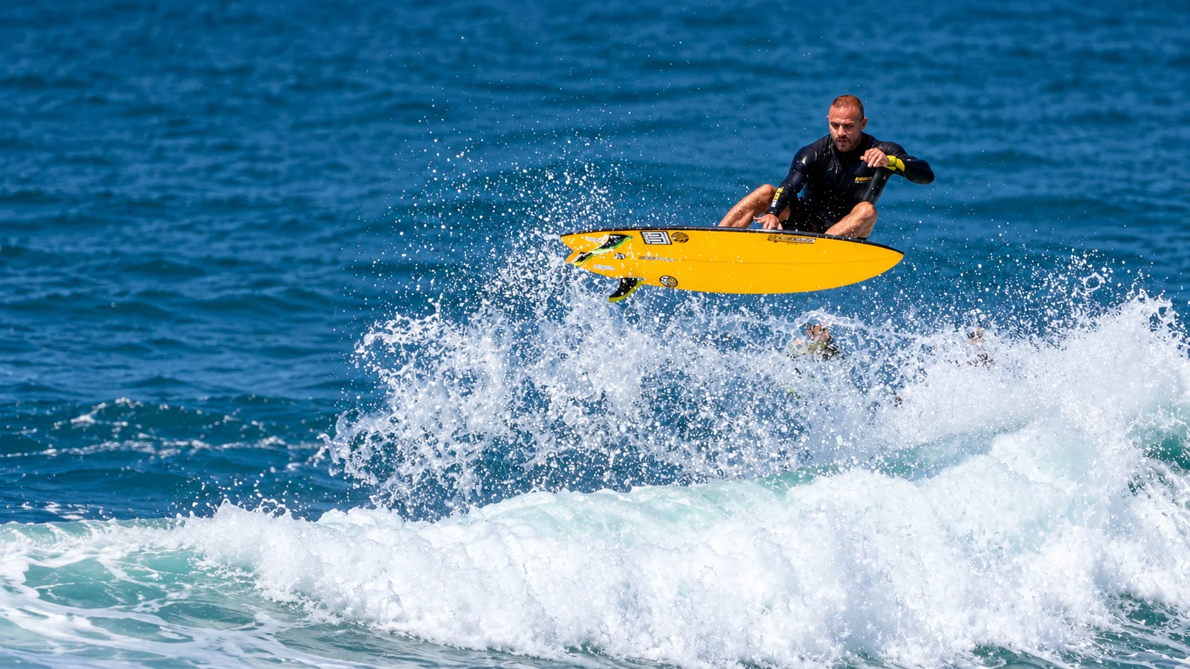 Surfista da SURFLIFE sobre uma prancha amarela em uma onda de Juquehy